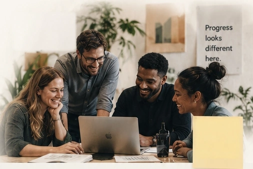 Four media teammates collaborating around a laptop
